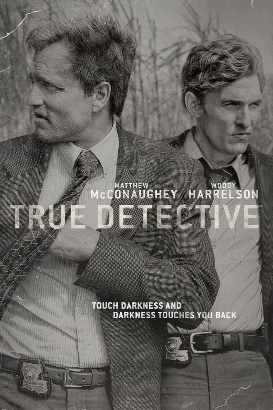 Auf einem schwarz-weißen „True Detective“-Poster mit dem Text „Berühre die Dunkelheit, und die Dunkelheit berührt dich zurück“ stehen zwei Männer in Anzügen nebeneinander und blicken in entgegengesetzte Richtungen. In der unteren Ecke ist auf einem unauffälligen Banner der Schriftzug „Jetzt IPTV kaufen und keine Szene verpassen“ zu lesen, der modernes Streaming nahtlos mit Noir-Atmosphäre verbindet.